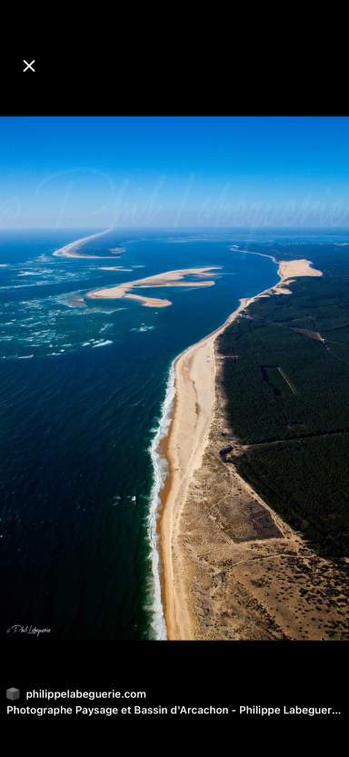 Vue aérienne d'une côte sablonneuse et d'eaux environnantes.